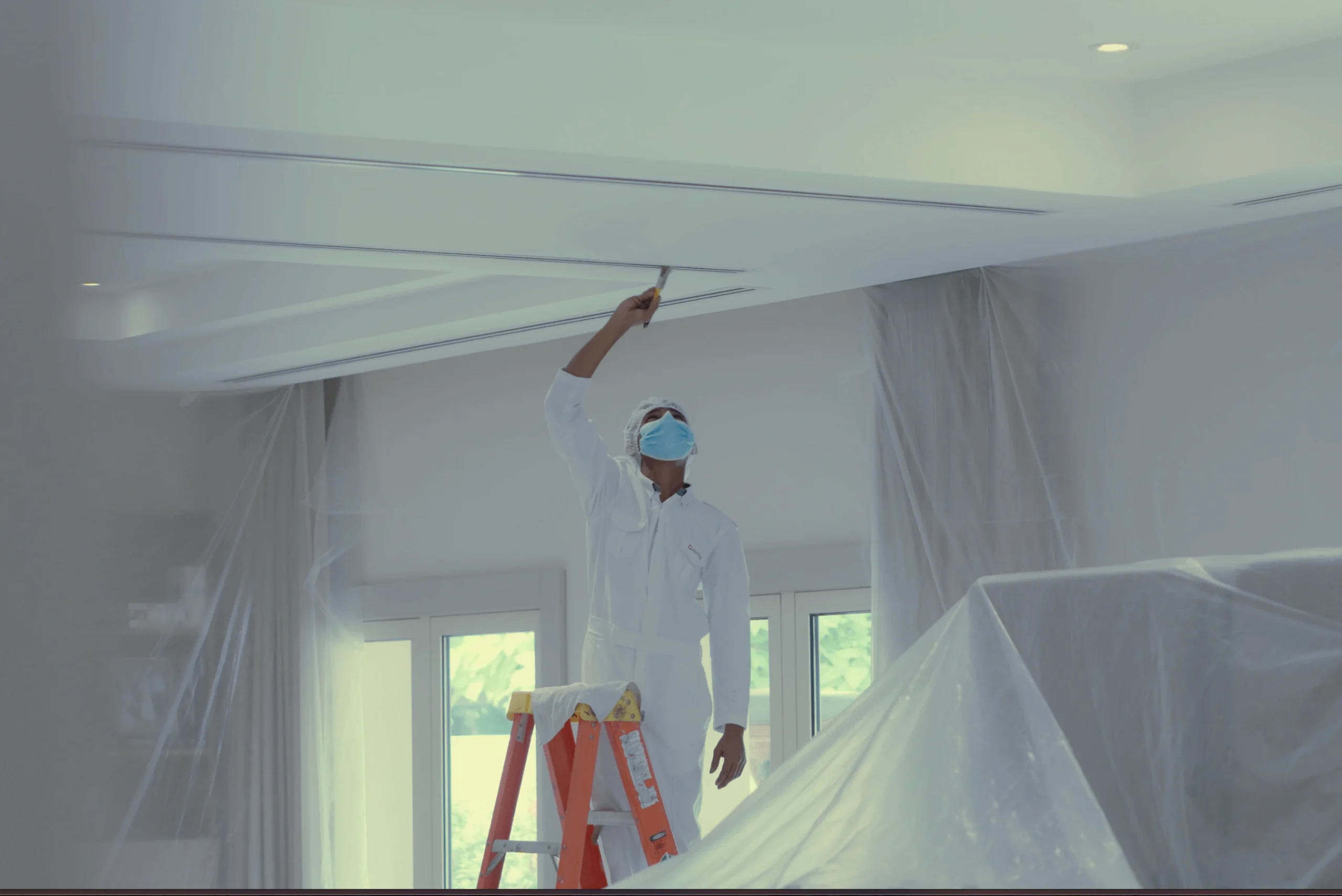 Guy wearing white and mask inspecting a AC duct